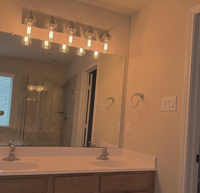 bathroom with double vanity, a stall shower, and a sink