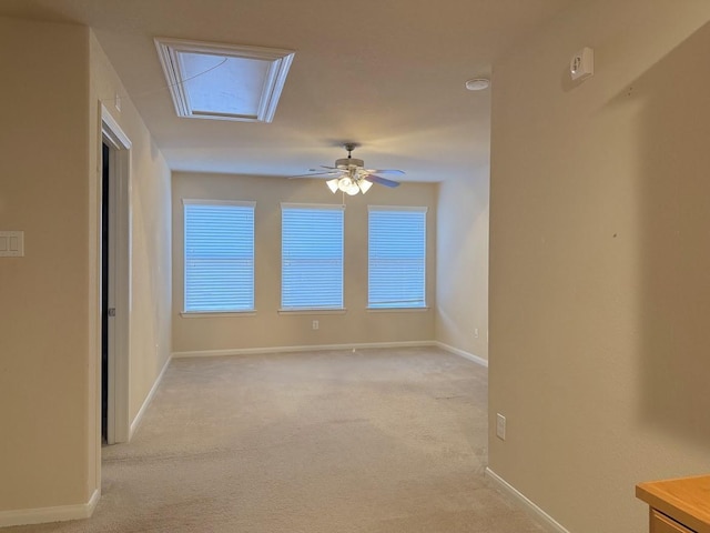 empty room featuring light carpet, baseboards, and a ceiling fan