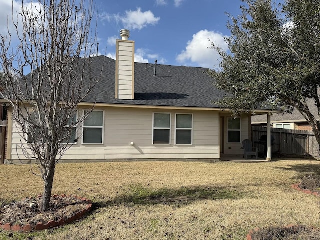 back of house featuring a patio area, a lawn, a chimney, and fence