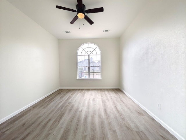 empty room with ceiling fan and light hardwood / wood-style floors