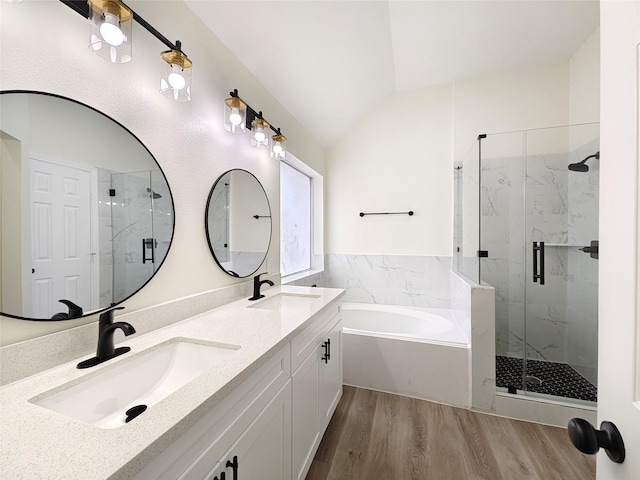 bathroom with plus walk in shower, lofted ceiling, hardwood / wood-style floors, and vanity