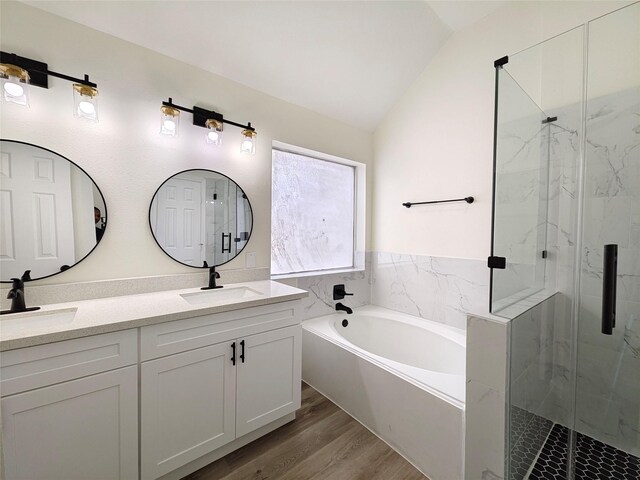 bathroom with vanity, hardwood / wood-style floors, vaulted ceiling, and shower with separate bathtub