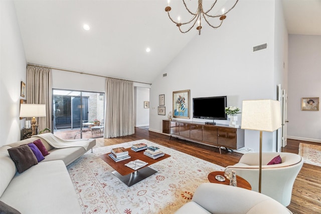 living room featuring high vaulted ceiling, a notable chandelier, and light hardwood / wood-style floors