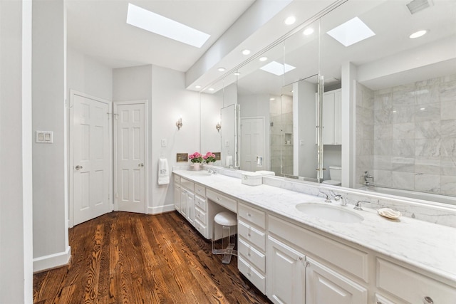 bathroom featuring tiled shower, vanity, toilet, and hardwood / wood-style floors