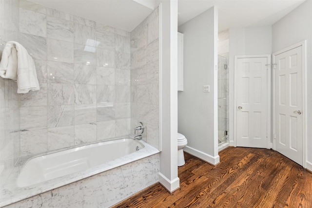 bathroom featuring wood-type flooring, plus walk in shower, and toilet