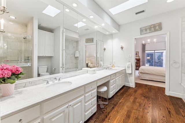 bathroom with wood-type flooring, toilet, a shower with shower door, and vanity