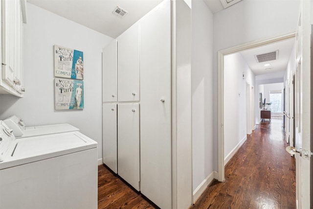 laundry room featuring cabinets, separate washer and dryer, and dark hardwood / wood-style flooring