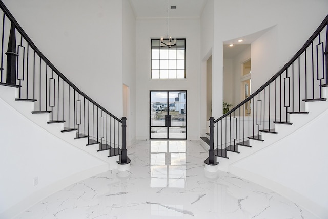 foyer featuring an inviting chandelier and a towering ceiling