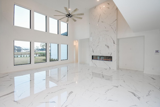 unfurnished living room featuring a fireplace and ceiling fan