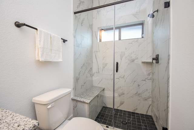 bathroom featuring toilet and a shower with door