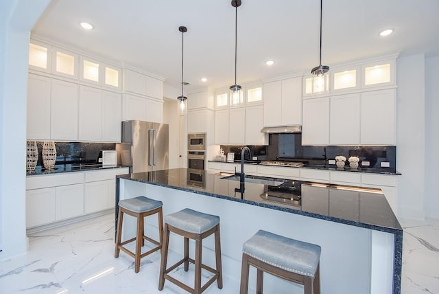 kitchen featuring stainless steel appliances, white cabinetry, and a large island with sink