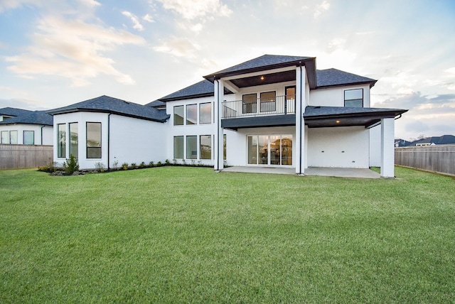 back of house featuring a balcony, a yard, and a patio