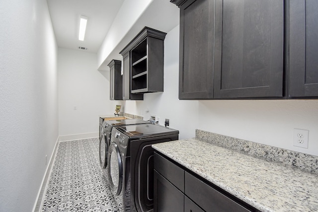 laundry room featuring cabinets and washer and clothes dryer