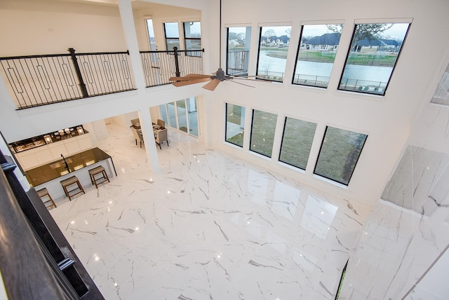 living room featuring a water view, a high ceiling, and a wealth of natural light