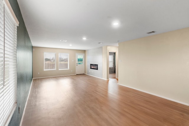 unfurnished living room featuring a fireplace and light hardwood / wood-style flooring