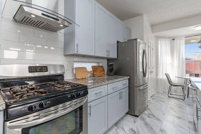 kitchen featuring extractor fan, appliances with stainless steel finishes, tasteful backsplash, light stone countertops, and a textured ceiling