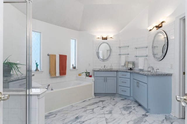 bathroom featuring vanity, lofted ceiling, and a bathing tub