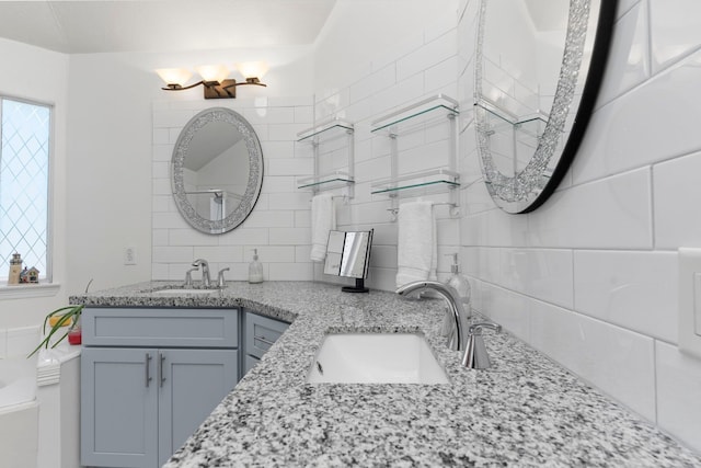 bathroom featuring vanity, tile walls, and decorative backsplash