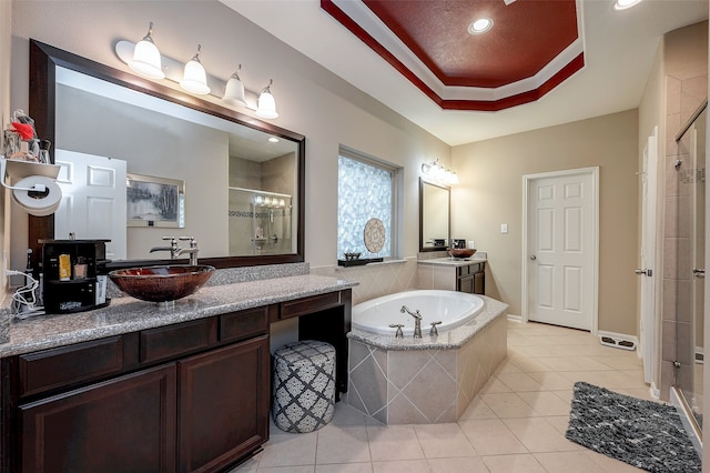 bathroom featuring vanity, a tray ceiling, tile patterned floors, and independent shower and bath