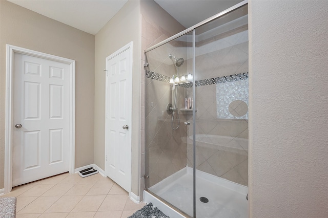 bathroom with an enclosed shower and tile patterned floors