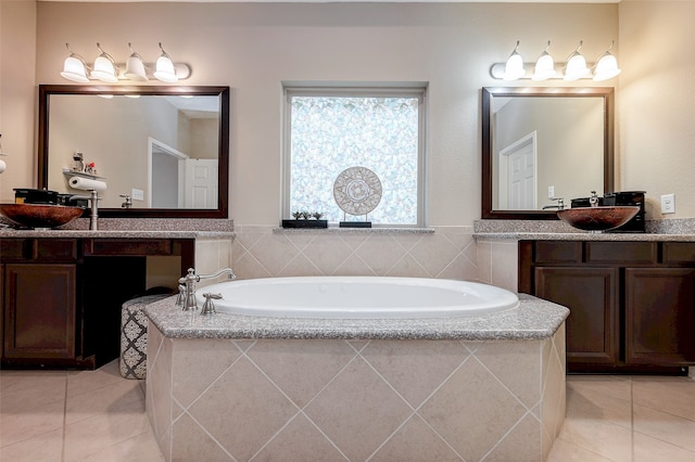 bathroom featuring tile patterned flooring, vanity, and a relaxing tiled tub