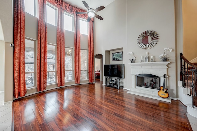 living room featuring hardwood / wood-style floors, ceiling fan, and a high ceiling