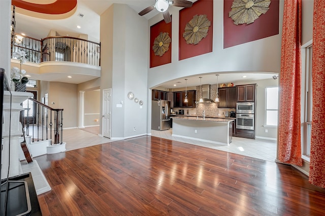 unfurnished living room featuring ceiling fan, sink, and light hardwood / wood-style floors