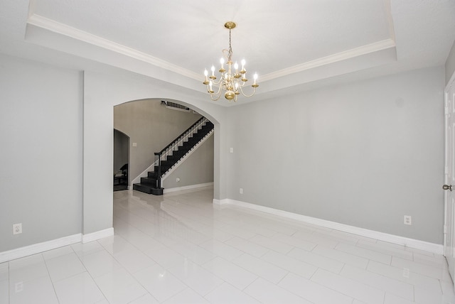 unfurnished room featuring light tile patterned flooring, ornamental molding, a tray ceiling, and a notable chandelier