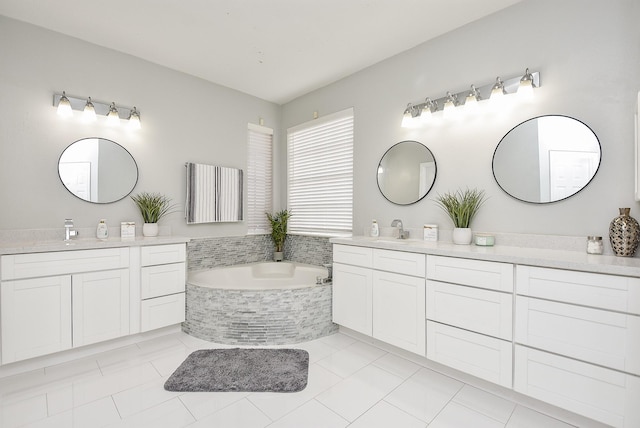 bathroom with tile patterned floors, vanity, and tiled bath