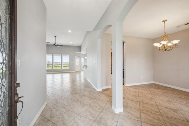 tiled foyer with ceiling fan with notable chandelier