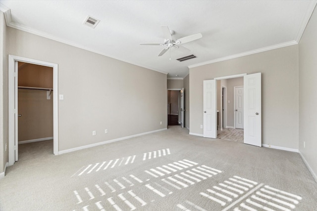 unfurnished bedroom with ceiling fan, ornamental molding, light carpet, a spacious closet, and a closet