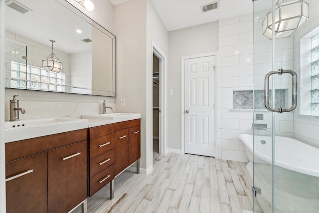 bathroom with vanity, shower with separate bathtub, hardwood / wood-style floors, and tile walls