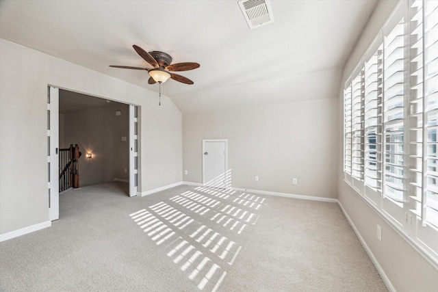 interior space featuring plenty of natural light, light colored carpet, and lofted ceiling