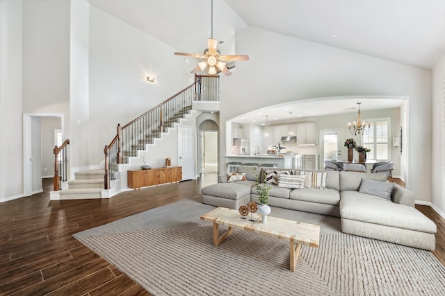 living room with hardwood / wood-style flooring, high vaulted ceiling, and ceiling fan with notable chandelier