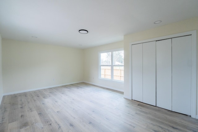 unfurnished bedroom featuring a closet and light wood-type flooring