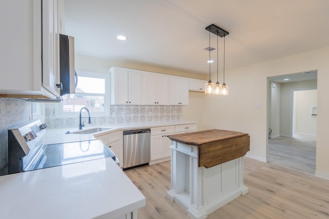 kitchen with white cabinetry, sink, stainless steel appliances, and a center island