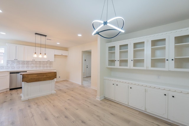 kitchen with white cabinetry, dishwasher, a kitchen island, pendant lighting, and backsplash