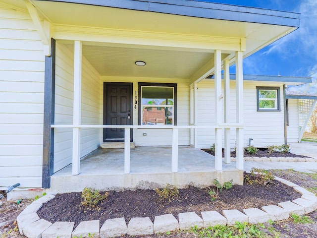 view of exterior entry featuring covered porch