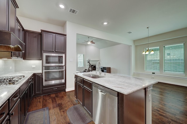 kitchen featuring decorative light fixtures, tasteful backsplash, sink, a kitchen island with sink, and stainless steel appliances