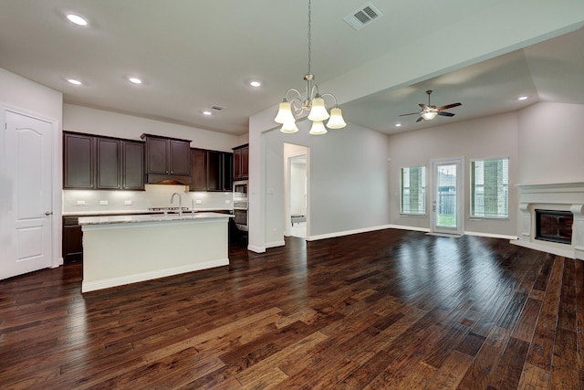 kitchen with pendant lighting, sink, dark hardwood / wood-style flooring, dark brown cabinetry, and stainless steel appliances