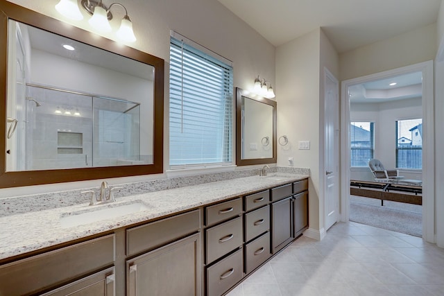 bathroom with tile patterned flooring, vanity, and walk in shower