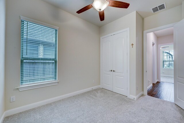 unfurnished bedroom with carpet, ceiling fan, and a closet