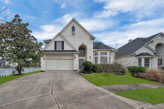 view of front of house with a garage, a water view, and a front yard