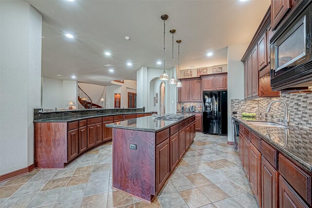 12403 Summer Lake Ranch Dr, Houston, TX 77044 - kitchen featuring dark stone countertops, backsplash, a kitchen island, a sink, and black appliances