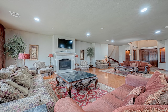 living room with a textured ceiling and light hardwood / wood-style floors