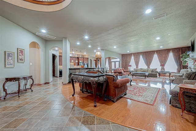 living room with a textured ceiling and light hardwood / wood-style flooring