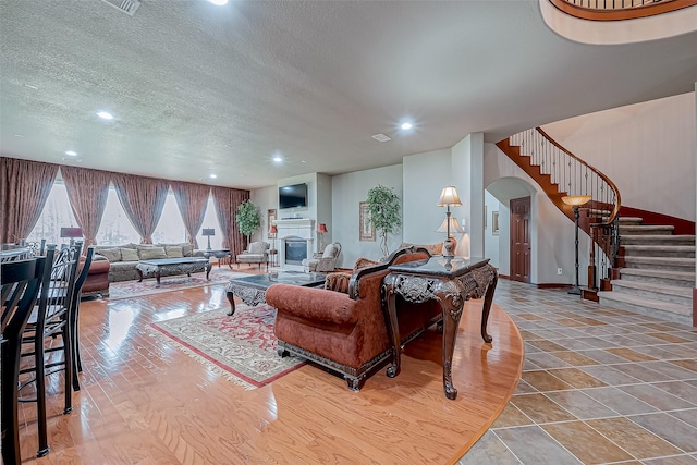 12403 Summer Lake Ranch Dr, Houston, TX 77044 - living room with stairs, recessed lighting, a textured ceiling, arched walkways, and wood finished floors