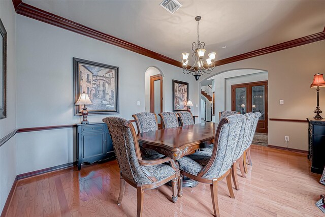 12403 Summer Lake Ranch Dr, Houston, TX 77044 - dining space with arched walkways, visible vents, light wood-style floors, and a notable chandelier