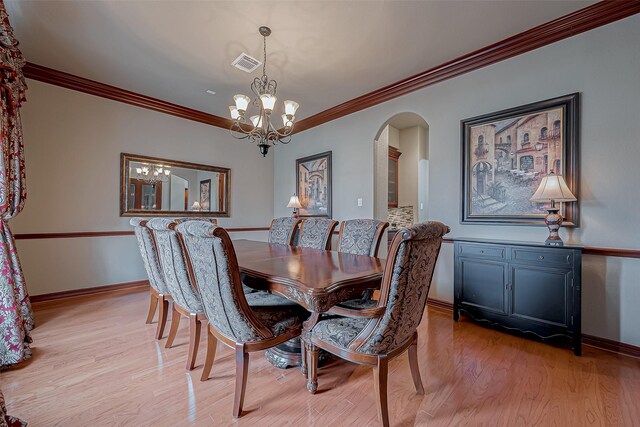 12403 Summer Lake Ranch Dr, Houston, TX 77044 - dining space featuring light wood finished floors, baseboards, visible vents, arched walkways, and an inviting chandelier