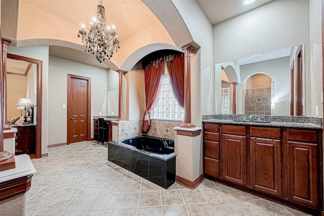 bathroom with vanity, tile patterned flooring, an inviting chandelier, and ornate columns